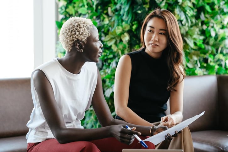 Twee vrouwen zitten op de bank en praten