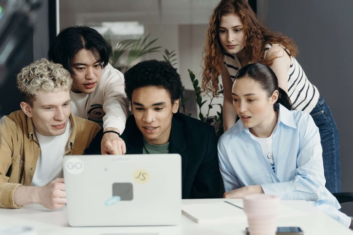 Gruppenfoto von Mitarbeitern verschiedener Geschlechter, die im Büro zusammenarbeiten, um Gender Diversity am Arbeitsplatz zu symbolisieren.