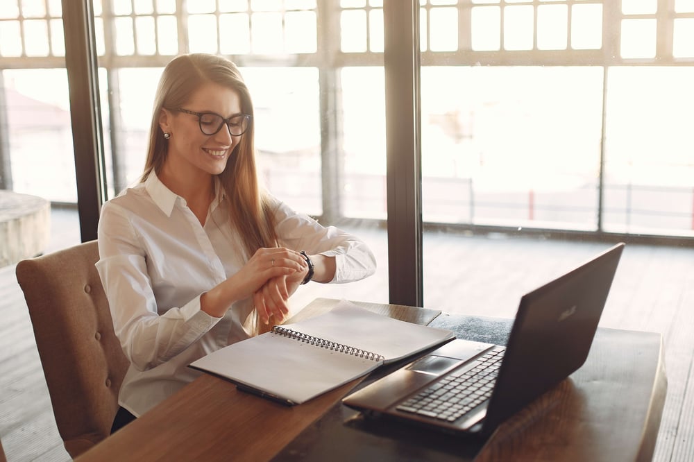 Arbeitszeitmodell: Mitarbeitende nutzen Laptop, um Arbeitszeit zu berechnen im modernen Büro