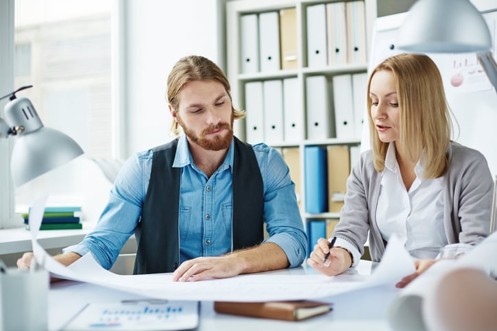 Male and female coworkers planning together in office