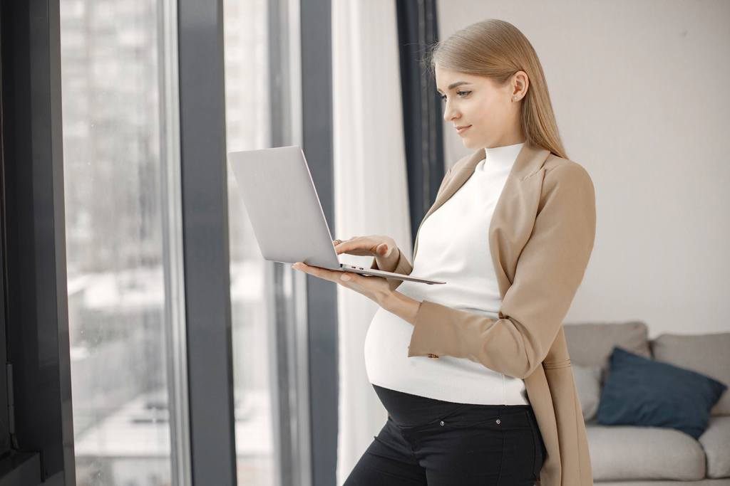 pregnant-lady-typing-on-a-laptop-while-standing-in-2022-12-23-00-34-25-utc_50