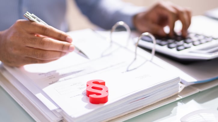 red paragraph sign on document booklet and hands using calculator symbolising law changes