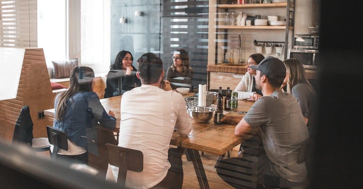Collega's vergaderen om tafel heen