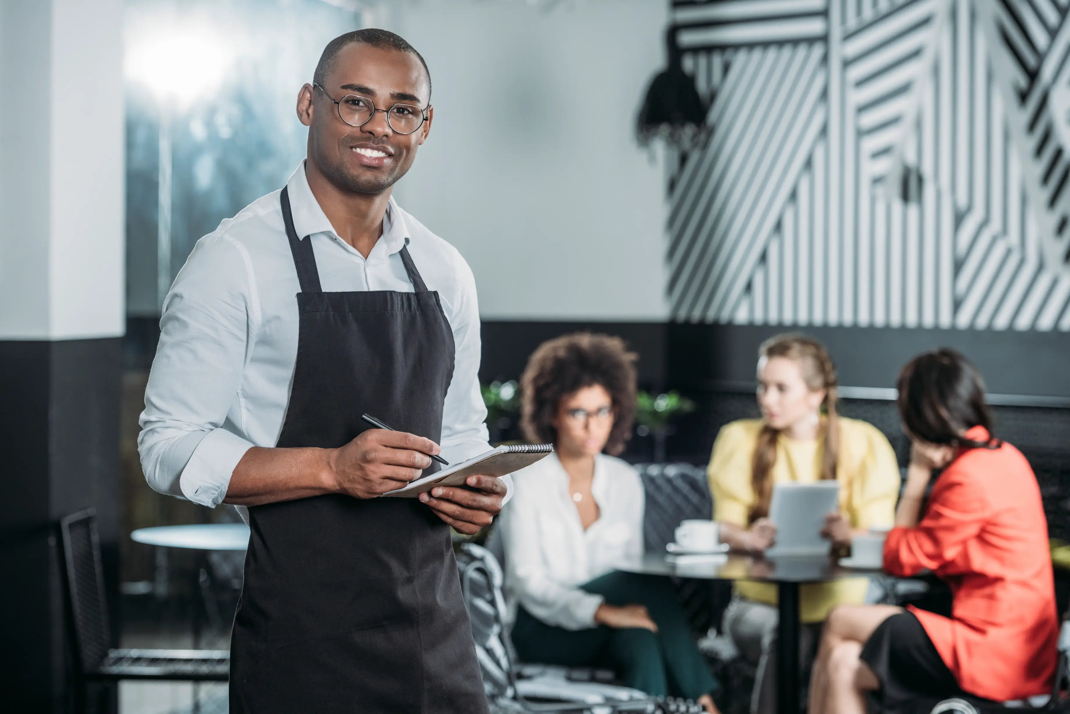 restaurant or cafe general manager or shift leader writing on notepad