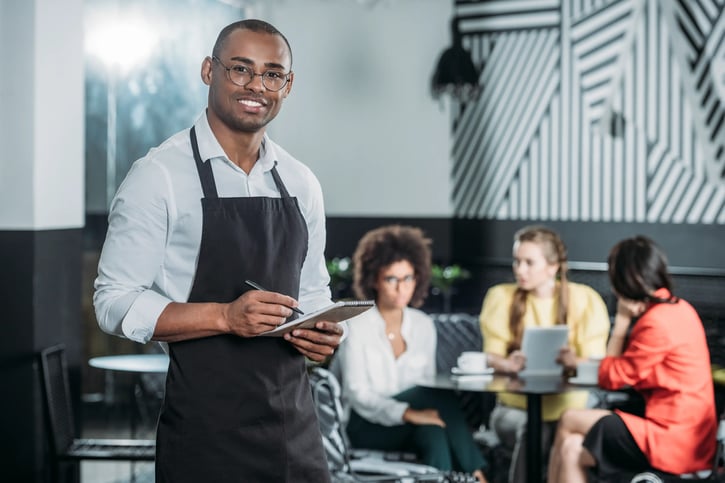 restaurant or cafe general manager or shift leader writing on notepad