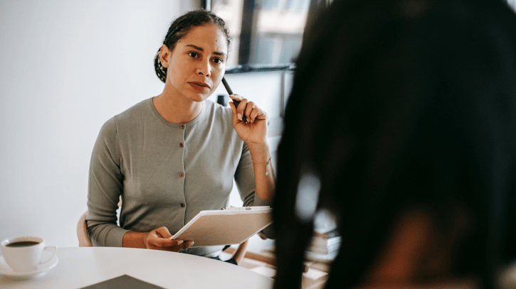 serious conversation between manager and employee who has been caught falsifying timesheets at work