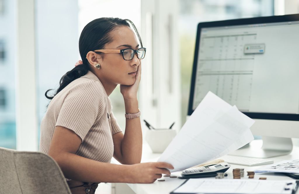 shot of a young businesswoman looking stressed out while looking at data on documents