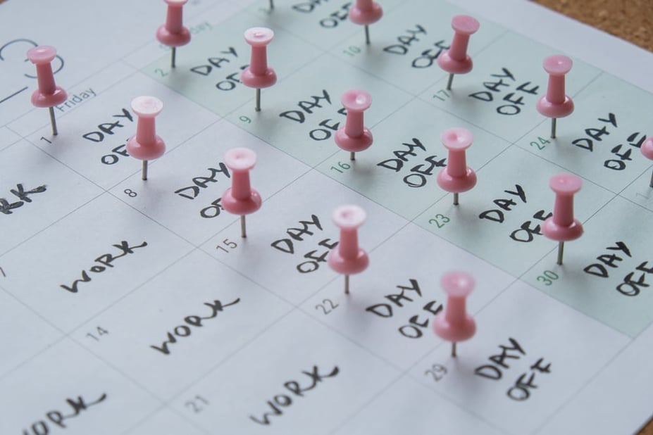 4 day work week schedule shown on a paper calendar with pinned emphasis on the days off 
