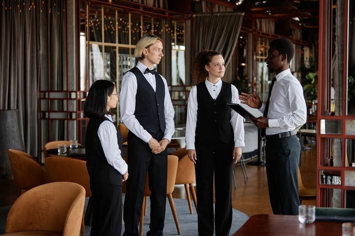 Diverse fine dining restaurant staff having a meeting before the shift starts