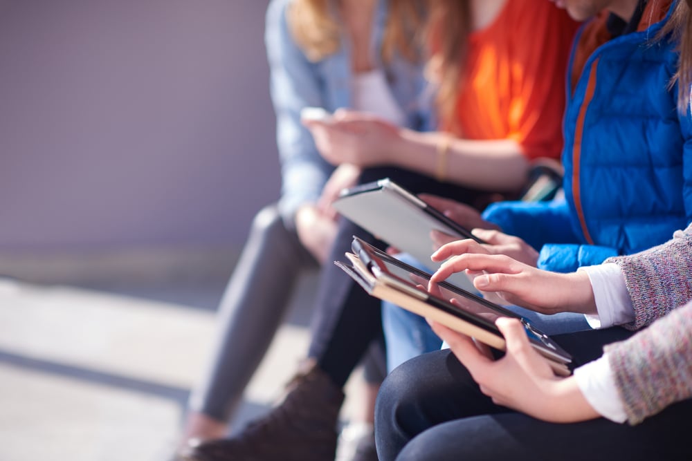 students group working on school  project  together on tablet computer  at modern university