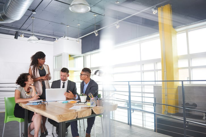 People manager standing in a meeting room leading a team meeting