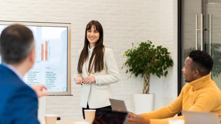 HR team discussing payroll analytics data on a screen