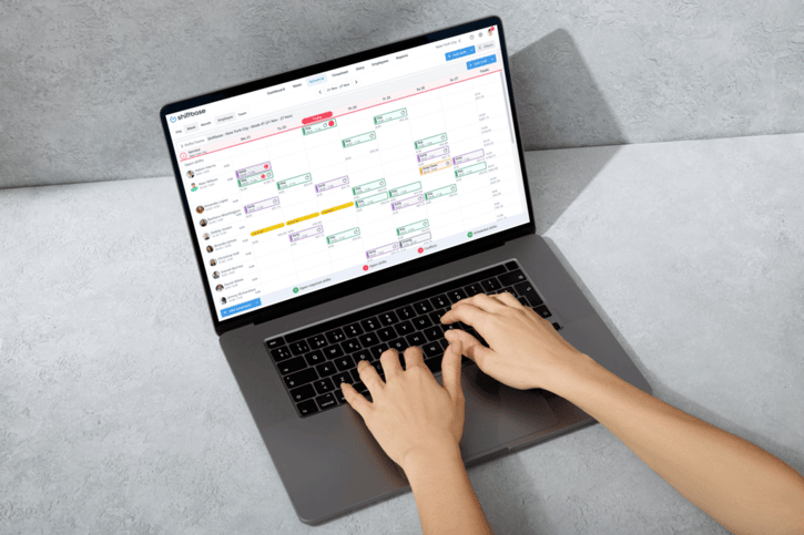 user hands on laptop working in Shiftbase workforce management tool planning in employee schedules