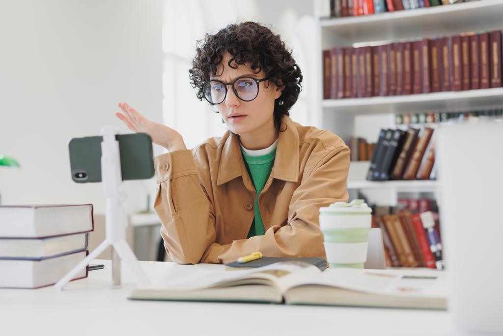 woman following a meeting with her mobile phone in her home office