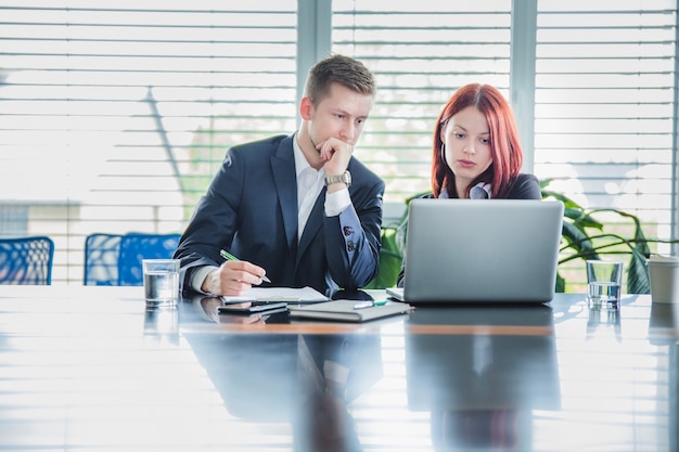 young employees going over business expenses document in meeting room