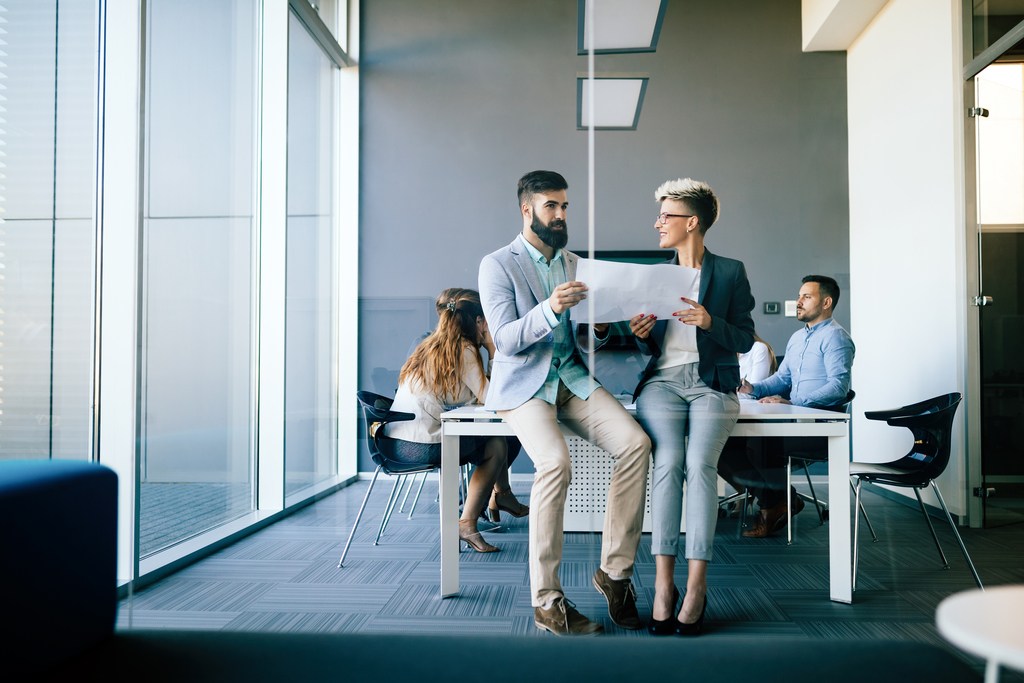 young professionals talking on break about business project in office meeting room