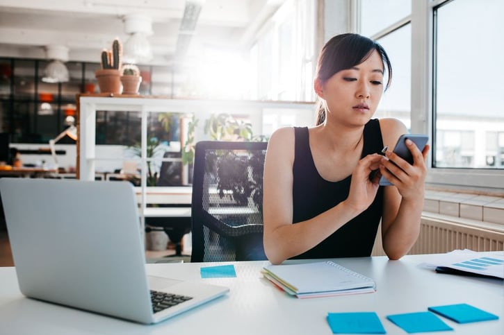 young business woman using mobile phone at work