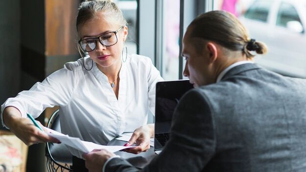 Arbeitgeber führt ein professionelles Kündigungsgespräch mit Mitarbeiterin im Büro.