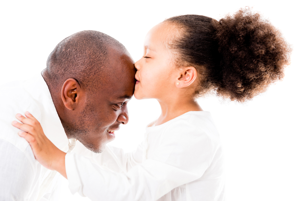 Girl kissing her father in the forehead - isolated over white backgorund